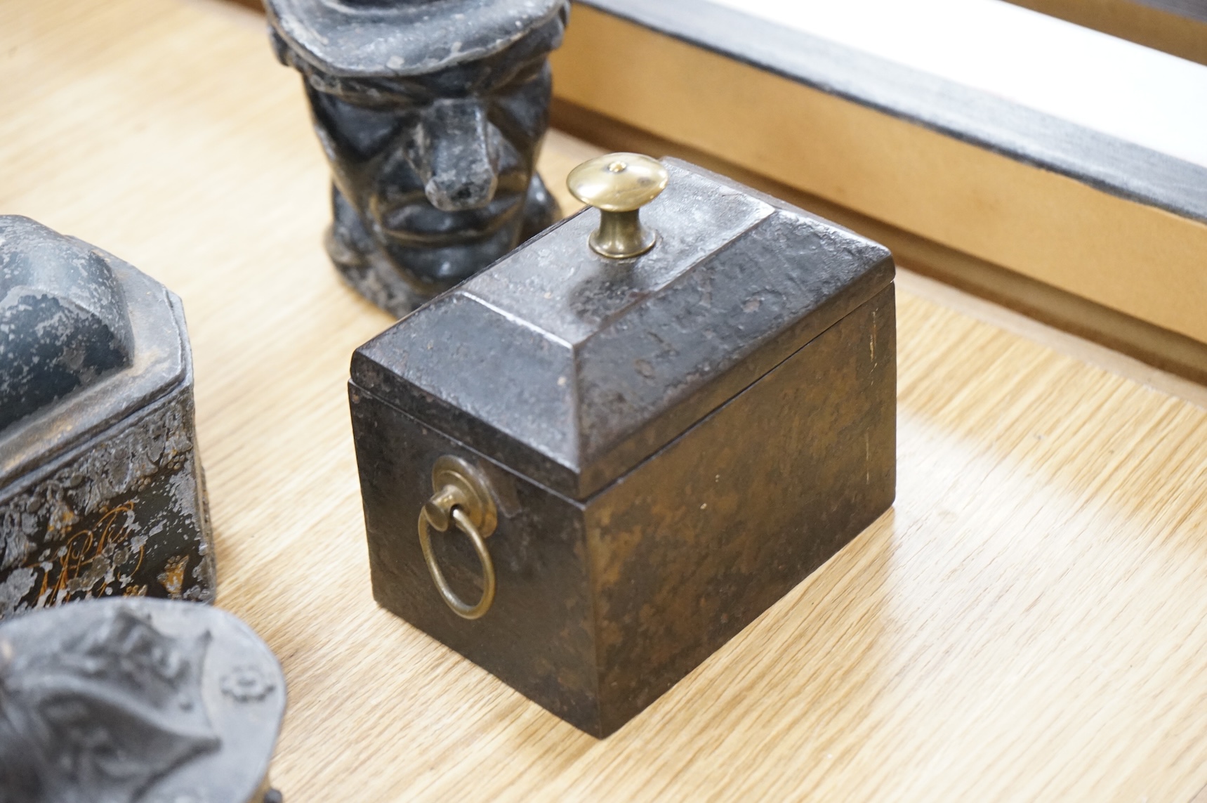 A collection of ten early 19th century lead tobacco boxes, to include an octagonal example, decorated in relief with the remains of red and gilt paint, largest 13cm wide